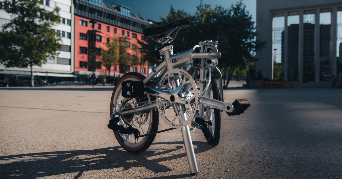 Silver folding bicycle parked in an urban city plaza